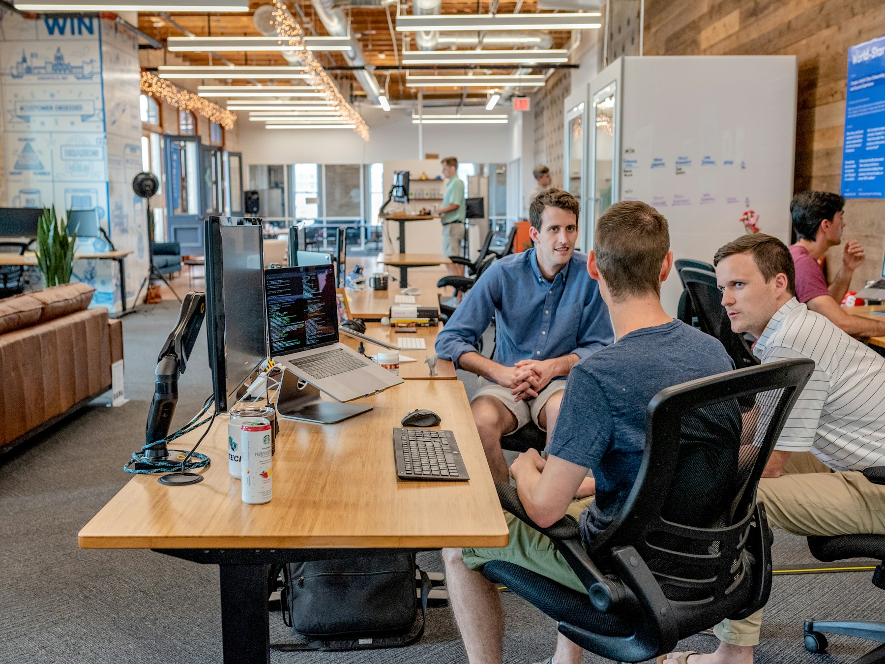 Colleagues collaborating around a computer in a bright studio